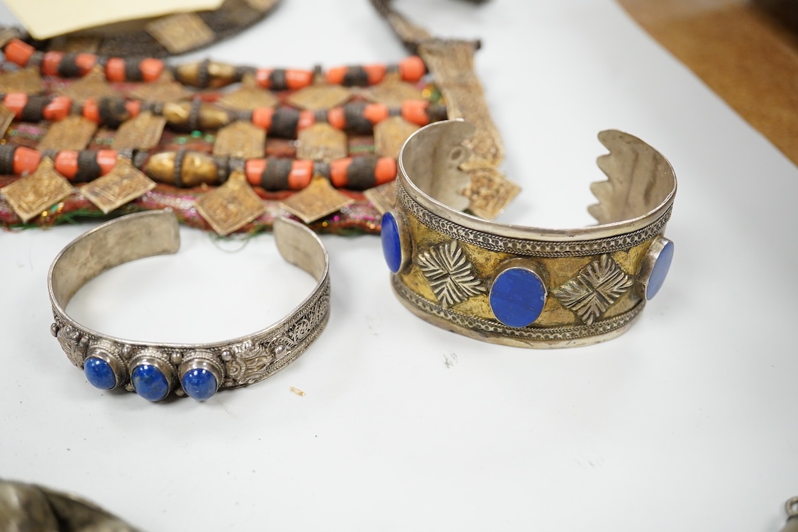 A collection of Bedouin white metal, gilt metal, lapis lazuli mounted jewellery, etc. from Oman